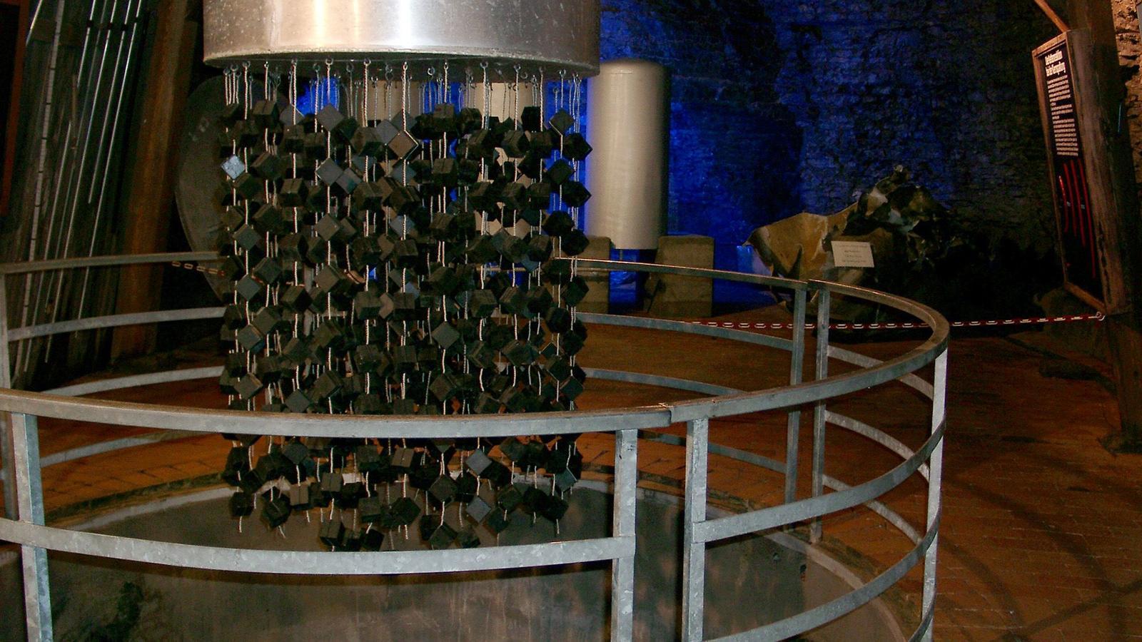 Primo piano di un reattore nucleare dietro sbarre di metallo.