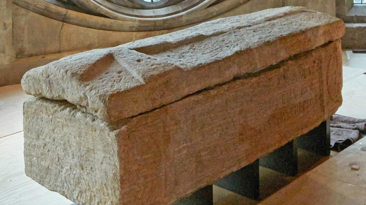 un sarcofago di calcare il cui coperchio è scolpito con una grande croce