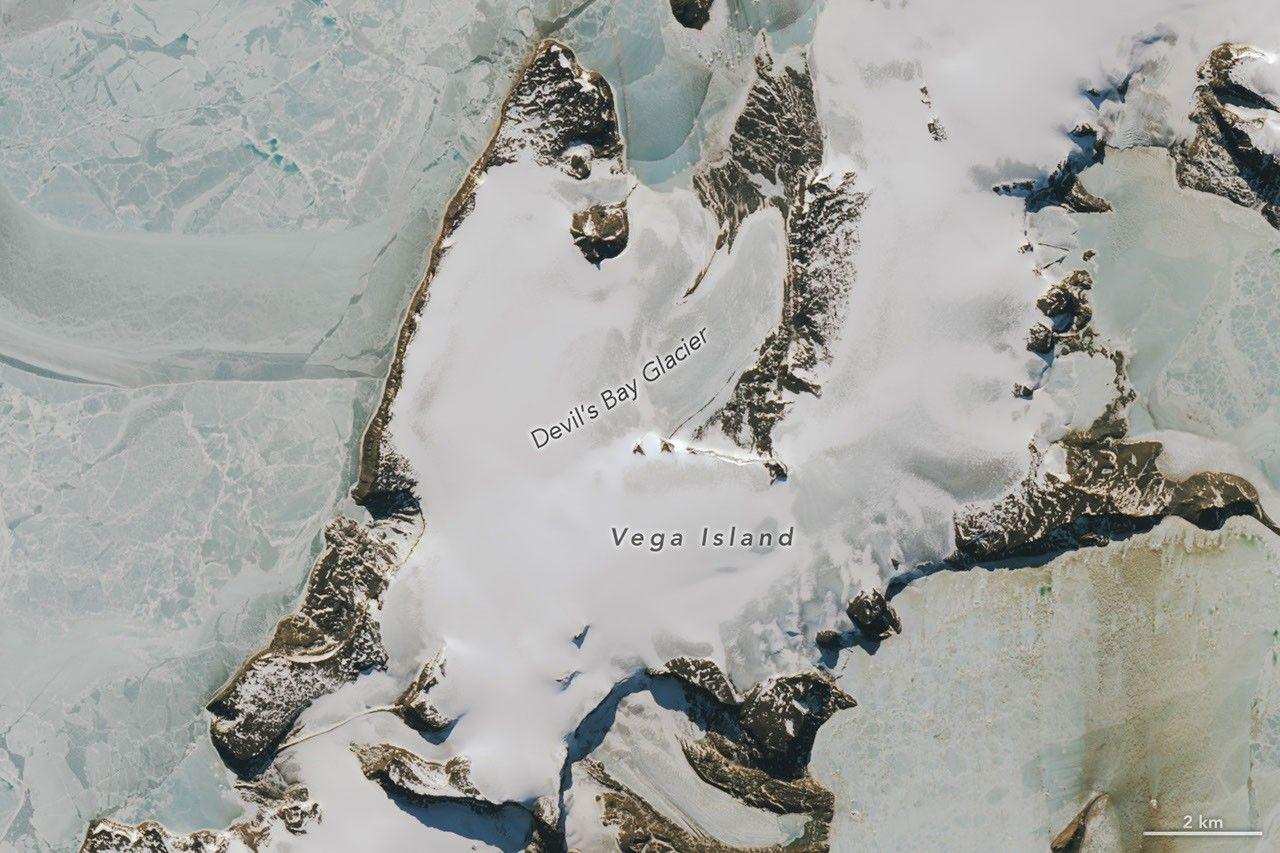 Una parte di un’isola antartica coperta di ghiaccio ricorda il profilo di un teschio ghignante. Alcune zone del volto sono grigie, dove la neve stagionale si è sciolta lasciando scoperto il ghiaccio nudo.