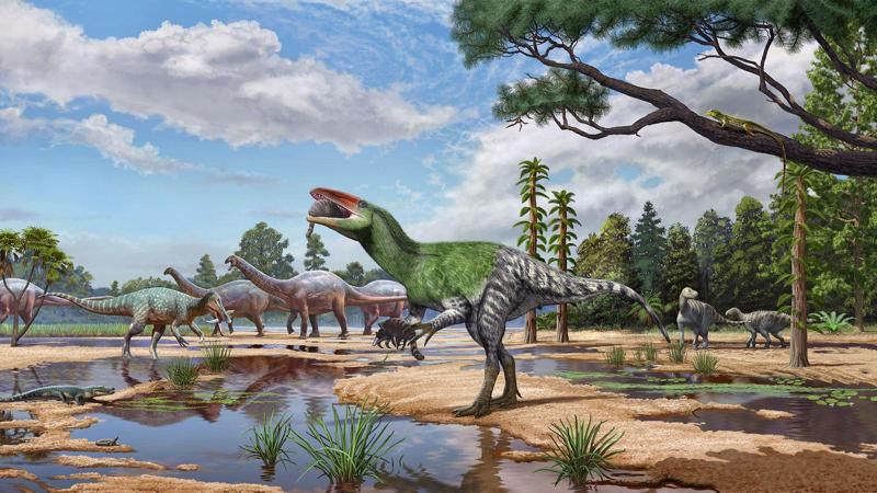 Illustrazione di un rapace verde a strisce, bipede, sul bordo di uno stagno, con dinosauri quadrupedi alle sue spalle.
