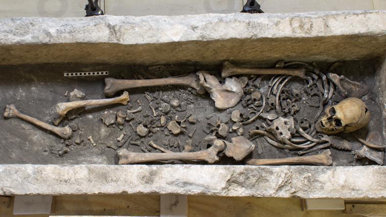 uno scheletro umano disteso per intero in un sarcofago, ma con diverse ossa fuori posto