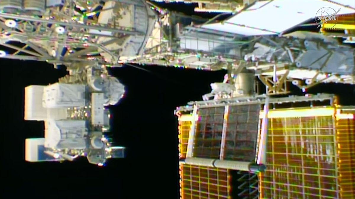 un pannello solare arrotolato si dispiega all’esterno di una stazione spaziale